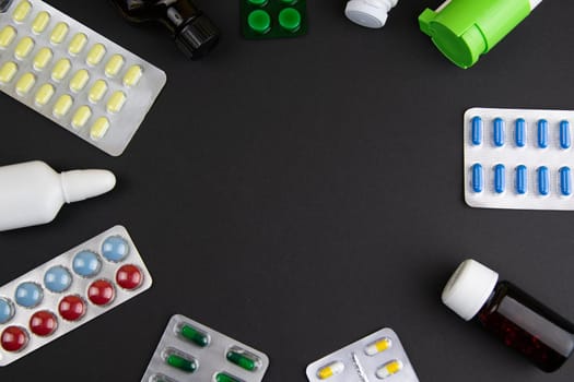 Pills of different colours lay on blue background. Colorful antibacterials pills, capsules of medicine.