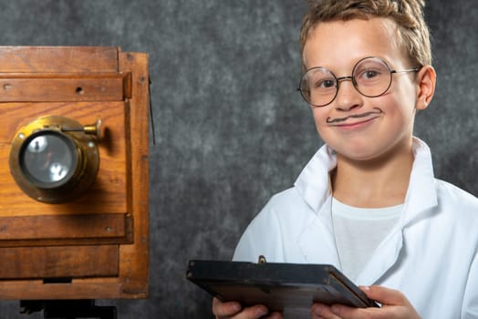 cheerful boy retro photographer with a vintage wooden camera