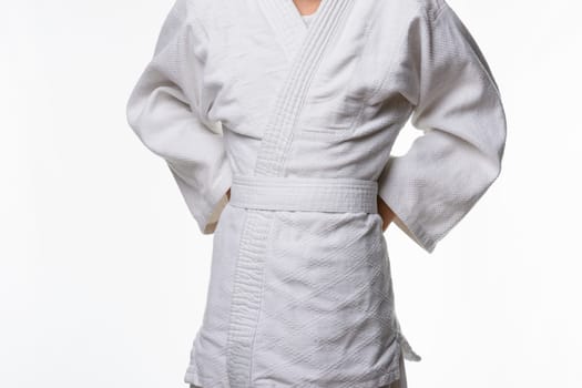 Stages of correct tying of the belt by a teenager on a sports kimono, step three