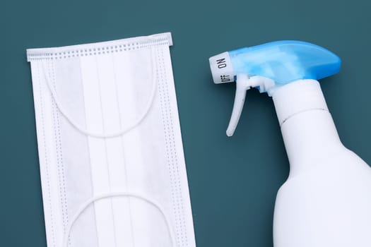 Disinfection spray with protection face mask on the color background
