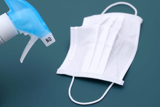 Disinfection spray with protection face mask on the color background