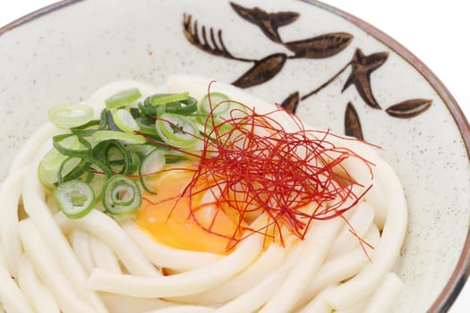 Japanese noodles in a ceramic bowl on white background