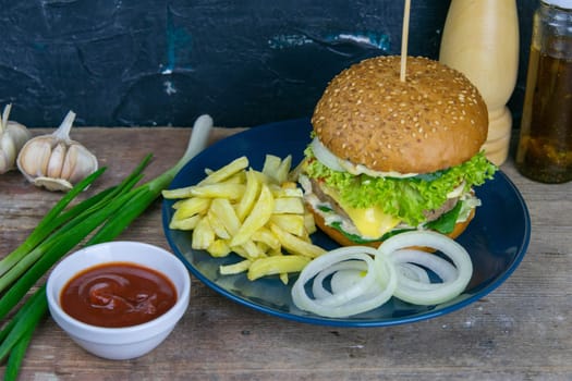 Two hamburgers close-up on a round wooden board, next to, tomatoes, chopped onions and spinach leaves. Top views with clear space