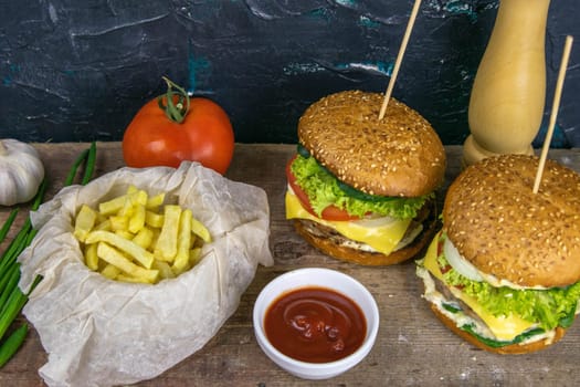 Two hamburgers close-up on a round wooden board, next to, tomatoes, chopped onions and spinach leaves.