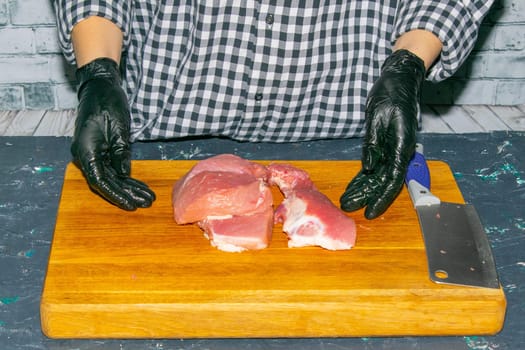 Preparing for the preparation of hamburgers. On a wooden board are lettuce leaves, chopped: tomatoes, cucumbers, onions, cutlets and sauces.