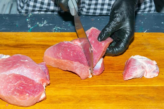 Preparing for the preparation of hamburgers. On a wooden board are lettuce leaves, chopped: tomatoes, cucumbers, onions, cutlets and sauces.