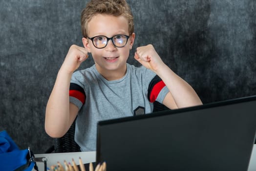 Happy boy sitting with a laptop computer