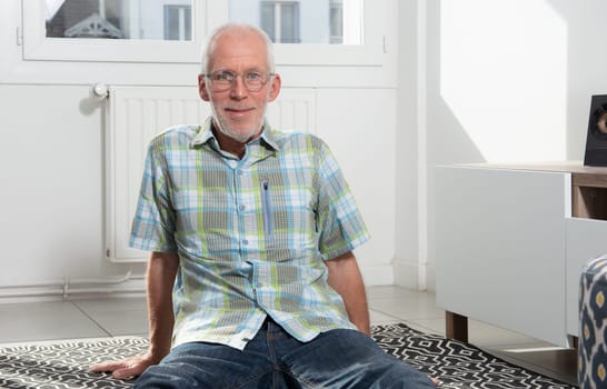 a senior man sitting on floor and resting