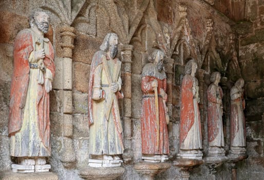 Plouha, France, August 15, 2019: Chapel of Kermaria an Iskuit - medieval wooden statues of saints - apostles - at the entrance to the chapel of Kermaria an Iskuit from 13th century