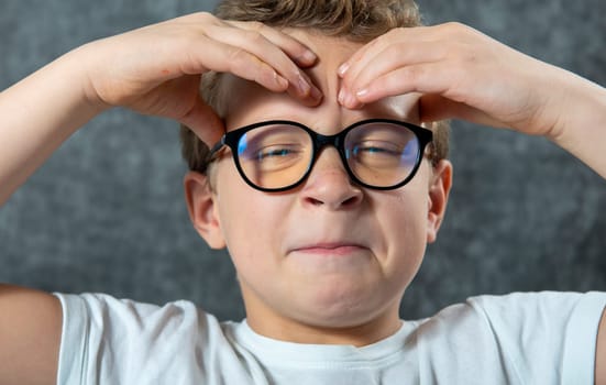 a boy with glasses has a headache