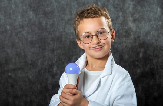 cute smiling child boy with a light bulb