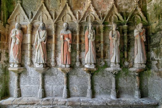 Plouha, France, August 15, 2019: Chapel of Kermaria an Iskuit - medieval wooden statues of saints - apostles - at the entrance to the chapel of Kermaria an Iskuit from 13th century