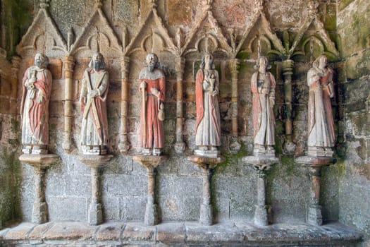 Plouha, France, August 15, 2019: Chapel of Kermaria an Iskuit - medieval wooden statues of saints - apostles - at the entrance to the chapel of Kermaria an Iskuit from 13th century
