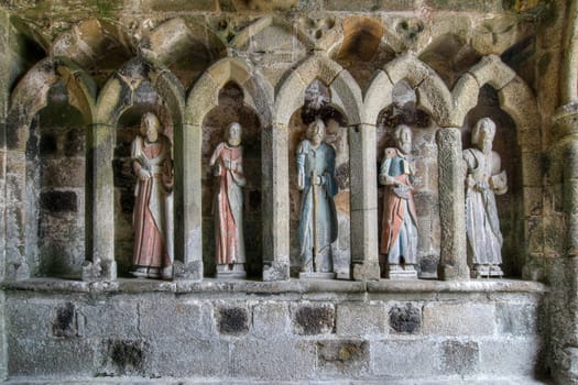 Plouha, France, August 15, 2019: Chapel of Kermaria an Iskuit - medieval wooden statues of saints - apostles - at the entrance to the chapel of Kermaria an Iskuit from 13th century