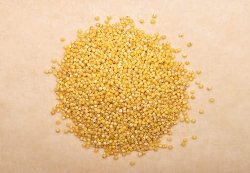 Raw millet on brown background