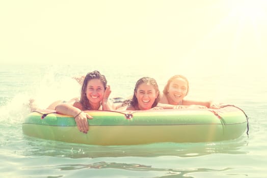 Happy girls in an inflatable watermelon at the beach