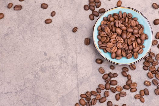 Roasted coffee beans on a brown textured background, hot drink ingredients