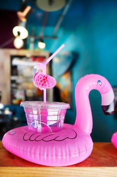 Cocktail glass with a flamingo-shaped straw and buoy on a bar counter in Mihama Town Resort American Village