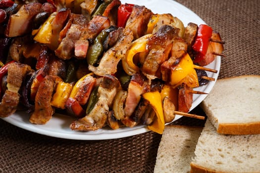 Grilled meat skewers with vegetables and bread