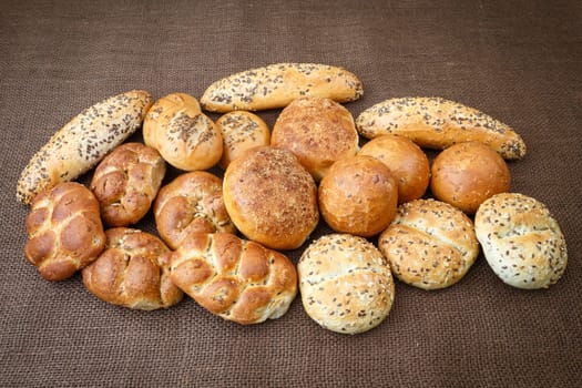 Different sorts of wholemeal breads and rolls on brown background
