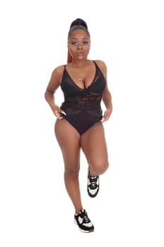 A lovely young African American woman standing in a black body suit,.smiling, isolated for white background.
