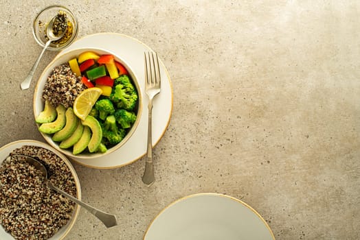 Healthy salad meal with quinoa, avocado and mixed fresh vegetables on grey background top view. Food and health. Healthy meal concept