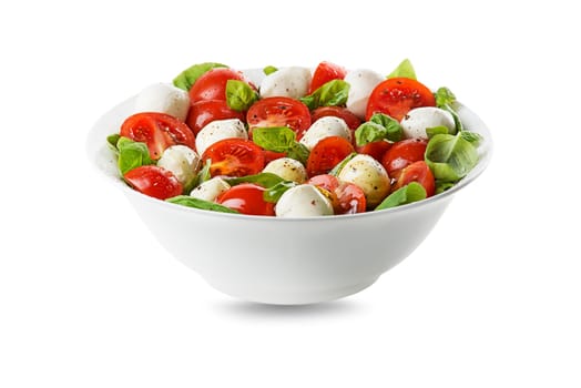Delicious caprese salad with ripe tomatoes and mozzarella cheese with fresh basil leaves. Italian food. Salad with mozzarella, tomatoes, basil, salt, black pepper, olive oil