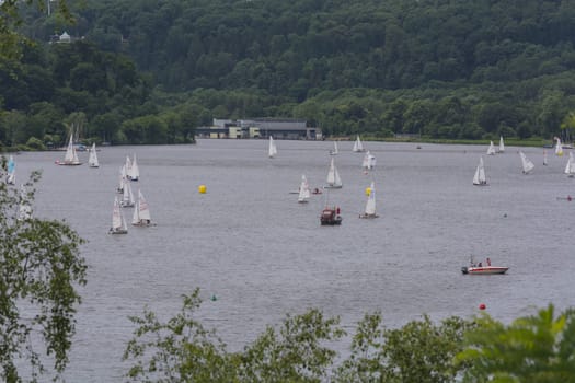 ESSEN, NRW, GERMANY - JUNE 10, 2017:.View of Lake Baldeney (Baldeneysee) in Germany. Right in the image Seaside Beach Baldeney. In the background sailing boats at a sailing regatta..