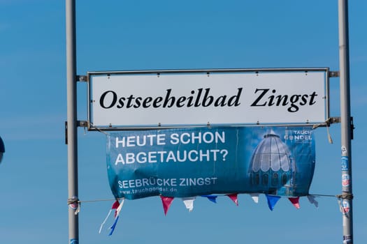ZINGT GERMANY - JULY 29 2018: Poster and sign with Zingst inscription on the wooden pier in the Baltic Sea. Darss Peninsula Fischland-Darss-Zingst Germany.At the pier of Zingst on the Baltic Sea in Germany