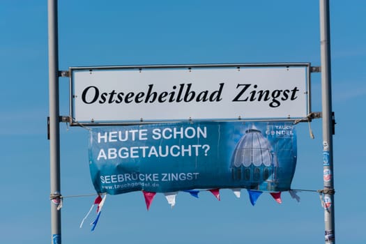 ZINGT GERMANY - JULY 29 2018: Poster and sign with Zingst inscription on the wooden pier in the Baltic Sea. Darss Peninsula Fischland-Darss-Zingst Germany.At the pier of Zingst on the Baltic Sea in Germany