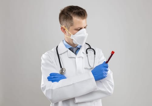 Doctor wearing respiratory mask and holding the Coronavirus Covid-19 blood sample