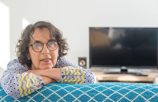 portrait of a beautiful brunette senior woman on the sofa