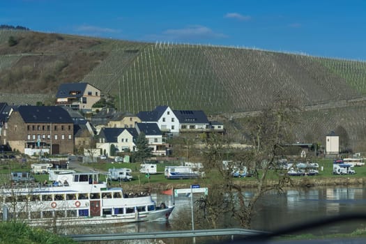 TRABEN-TRARBACH, GERMANY - MARCH 26, 2016:.Passenger ship MS Berlin on the Moselle near the town of Traben-Trarbach in Germany. In the background mobile home on a campsite