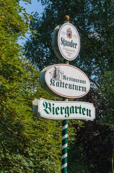 ESSEN, NRW, GERMANY - JULY 23, 2014:  Advertising Sign in Essen district of Kettwig near the restaurant at the Kattenturm. Green and white striped wooden post with advertising surface.