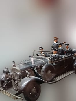 RATINGEN, NRW, GERMANY - AUGUST 17, 2018:.Selective focus views of a model car made of sheet metal with tin soldiers on an exhibition..