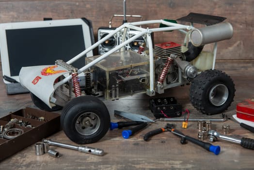 a computer tablet with RC radio control car and tools