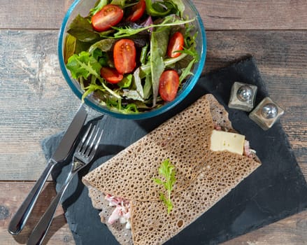 Breton crepe with cheese and bacon on the wooden background
