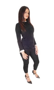 A gorgeous young woman standing in profile in jeans and back.sweater, looking away and sad, isolated for white background.