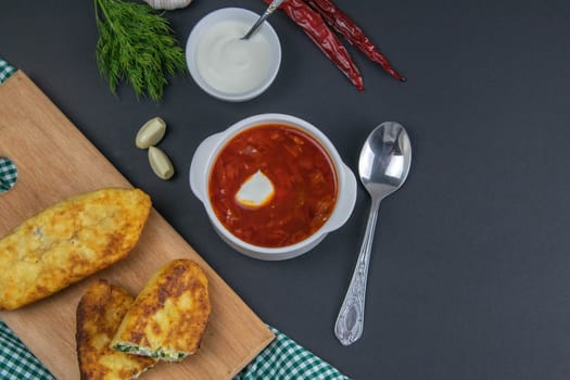 Traditional Ukrainian Russian borsch with white sour cream. Plate of borscht red beetroot soup on a table. Borsch on top. Traditional Ukrainian cuisine.
