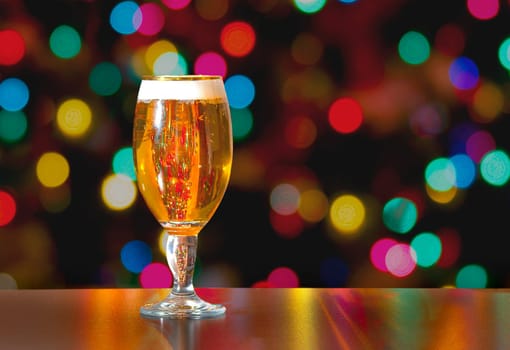 A Cup of Stella Artois full of beer with holiday colorful lights in background