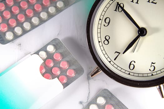 Birth control pills with a clock and a marble background