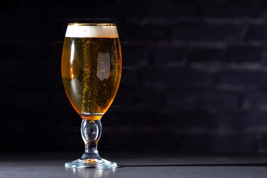 A cups of Stella Artois full of beer with a black brick background