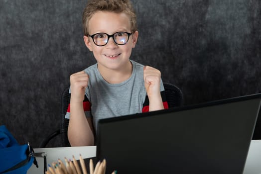 Happy boy sitting with a laptop computer