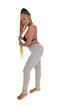 Beautiful young woman standing in the studio in gray pants.her long hair and bare feet, isolated fir white background.
