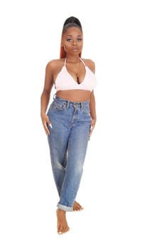 A gorgeous African American woman standing in jeans and a pink bra.in the studio looking, isolated for white background.