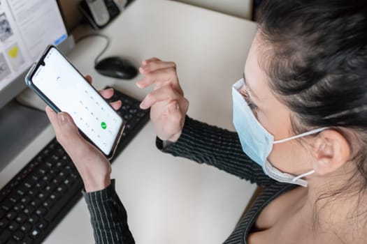 Young business woman working from home wearing protective mask. Coronavirus. Business woman in quarantine for coronavirus wearing protective mask. Working from home.