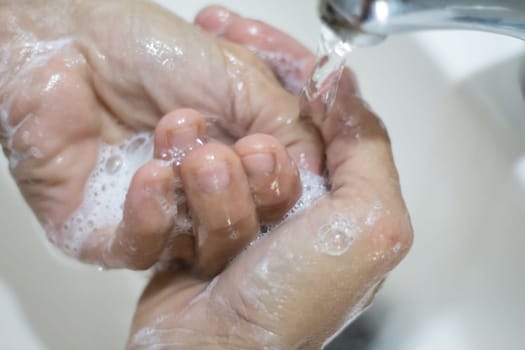 woman's hands washing with soap and water