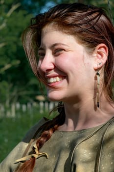 Portrait of a laughing young girl with dark hair against blurred background