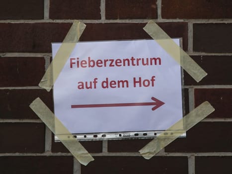 Signpost to the fever center in the courtyard during the corona virus pandemic