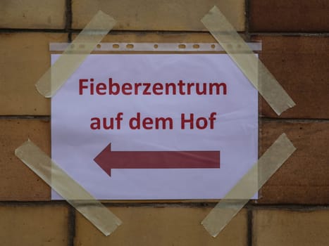 Signpost to the fever center in the courtyard during the corona virus pandemic